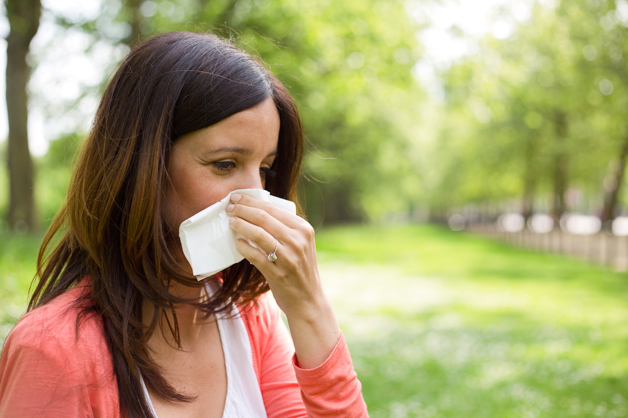Woman Blowing Nose in KC Park from Springtime Allergies